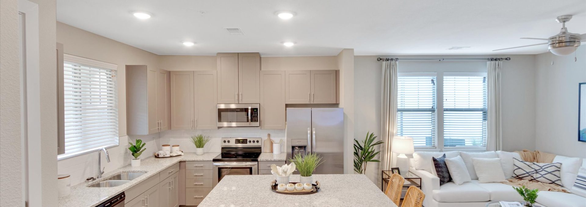 a large open kitchen and living room with white cabinets at The Town Arlington