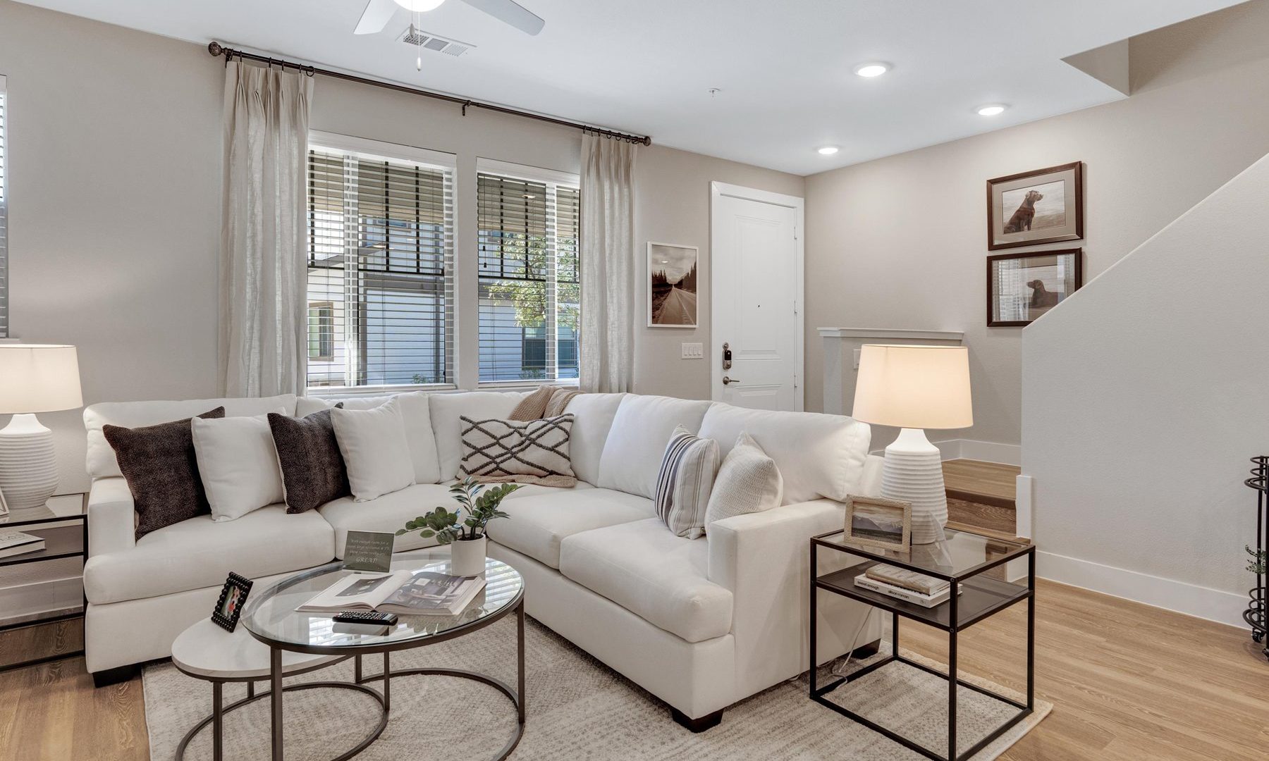 a living room with white furniture and hardwood floors at The Town Arlington