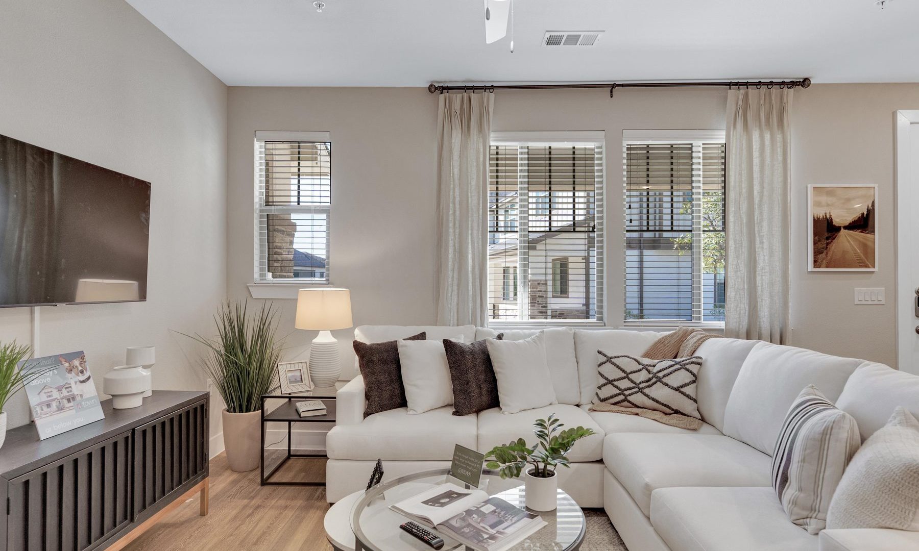 a living room with white furniture and a ceiling fan at The Town Arlington