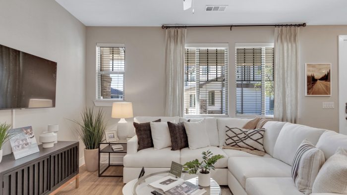 a living room with white furniture and a ceiling fan at The Town Arlington