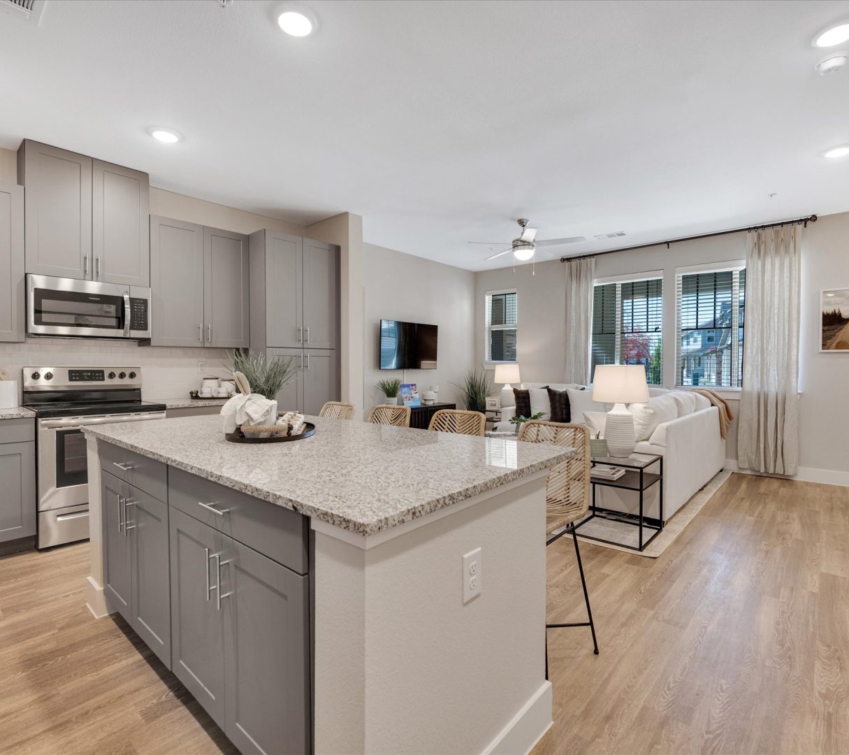 a large open kitchen with stainless steel appliances and gray cabinets at The Town Arlington