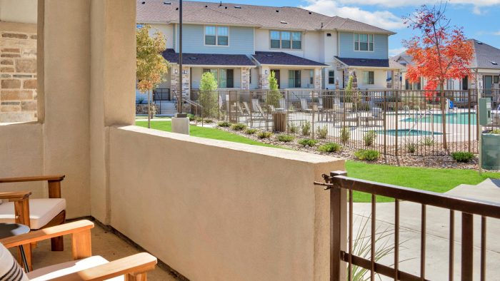 a balcony with chairs and a pool in the background at The Town Arlington